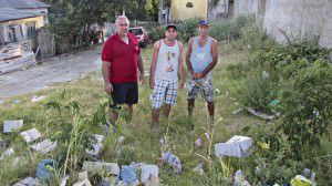 Presidente da associação Diego Mancini (centro) e moradores mostram o local do início da estrada que acabou virando um lixão a céu aberto. Foto: Fábio Barcelos