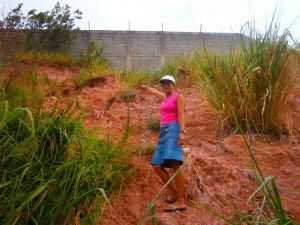 A moradora Luiza Berizálio teme que o barranco da rua Um venha abaixo e ainda traga o muro construído sobre ele. Foto: Gabriel Almeida