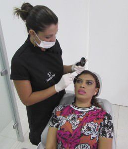 A design Kamila Freitas desenhando a sobrancelha de Léa De Santis. Foto: Fábio Barcelos