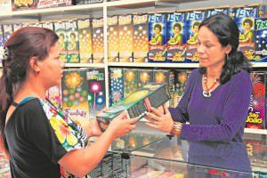 Maria Aparecida, da Arte Fogos, orienta cliente para o uso dos fogos de artifício que viram febre em tempos de festas juninas. Foto: Edson Reis