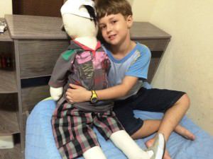 Yuri, de sete anos, levou o boneco para casa e já fez sua doação de roupa, que será distribuída em orfanatos da Serra. Foto: Divulgação / Colégio Adventista