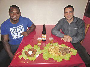 Rafael e Allan mostram a especialidade do Degustar: o bolinho de feijoada e a tradicional porções de carne de sol com aipim. Foto: Fábio Barcelos