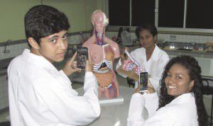 Os alunos Vinicius e Emanueli (primeiro plano) com a professora Kelly. Foto: Fábio Barcelos