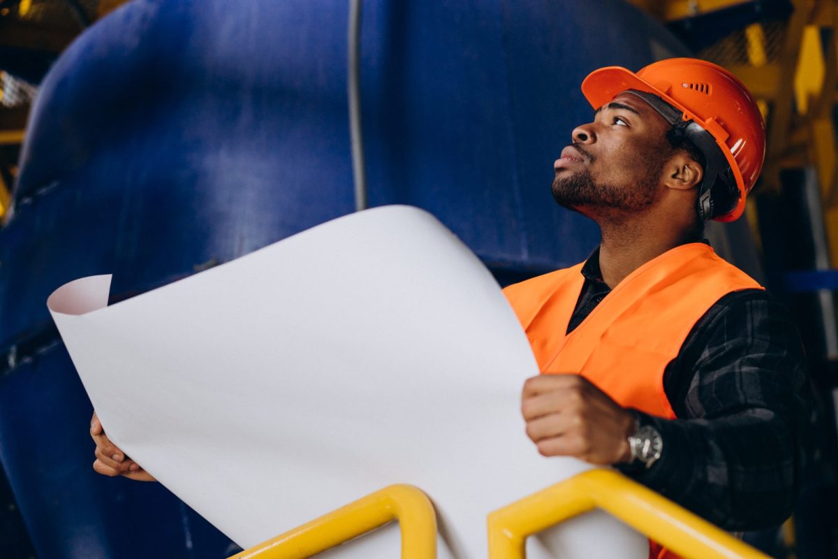 african-american-worker-standing-in-uniform-wearing-a-safety-hat-in-a-factory