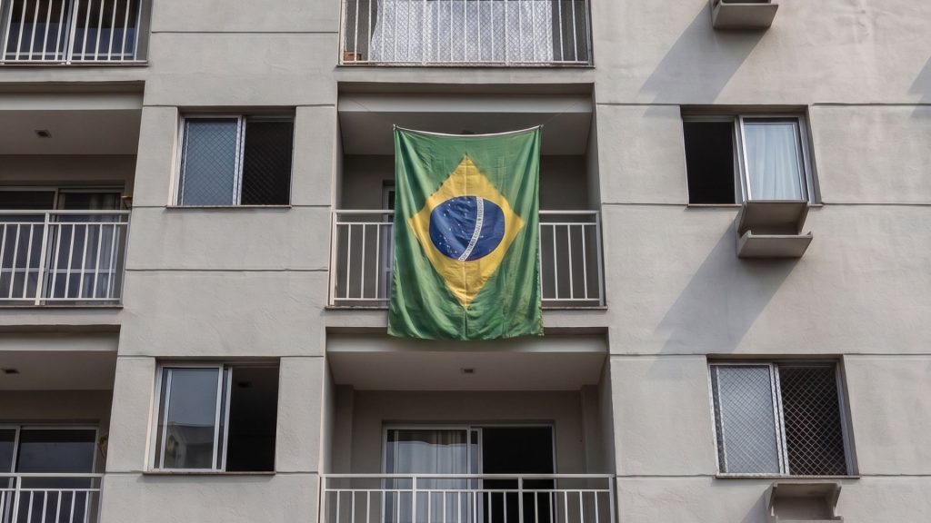 Bandeira do Brasil durante jogo da copa do mundo na varanda do apartamento de condomínio