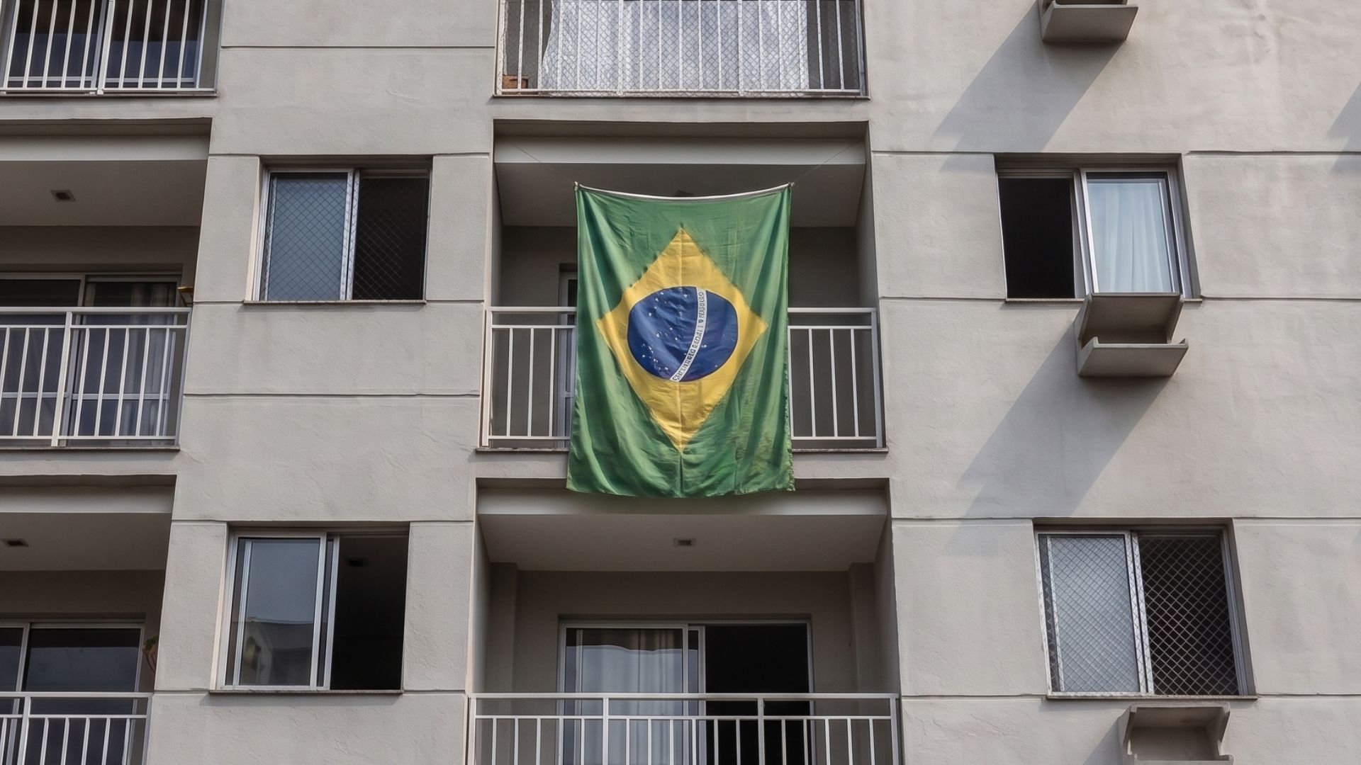 Bandeira do Brasil durante jogo da copa do mundo na varanda do apartamento de condomínio