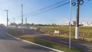 Terreno dos Correios na Serra visto da avenida, cercado por muro e mato