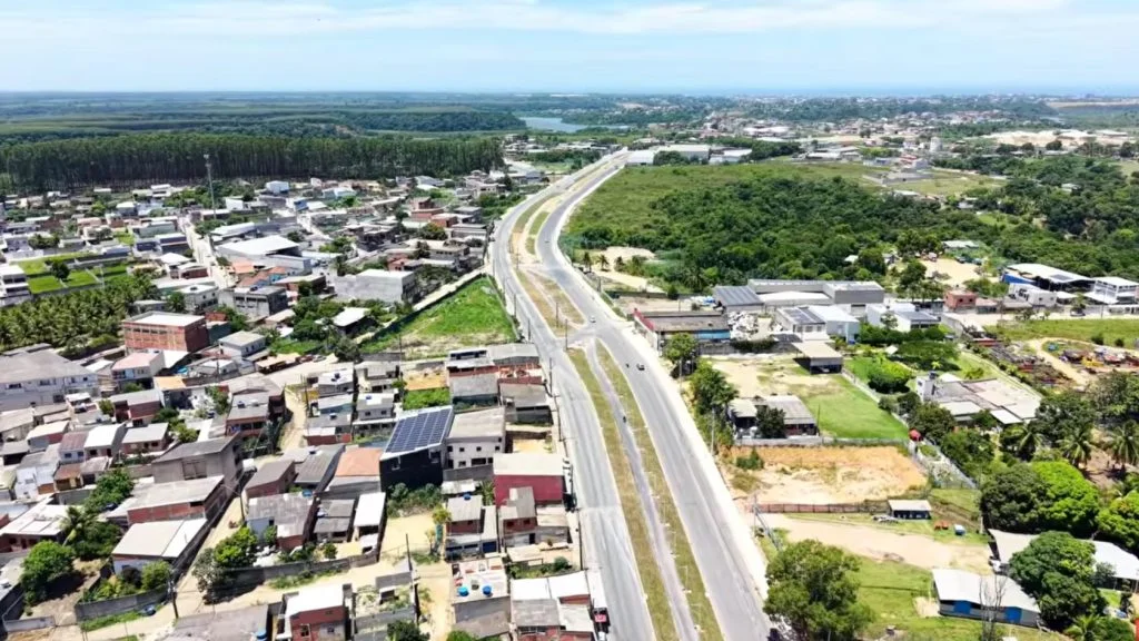 Vista aérea da Avenida Porto Dourado duplicada, acesso ao novo condomínio de lotes na Serra, com ciclovia no canteiro