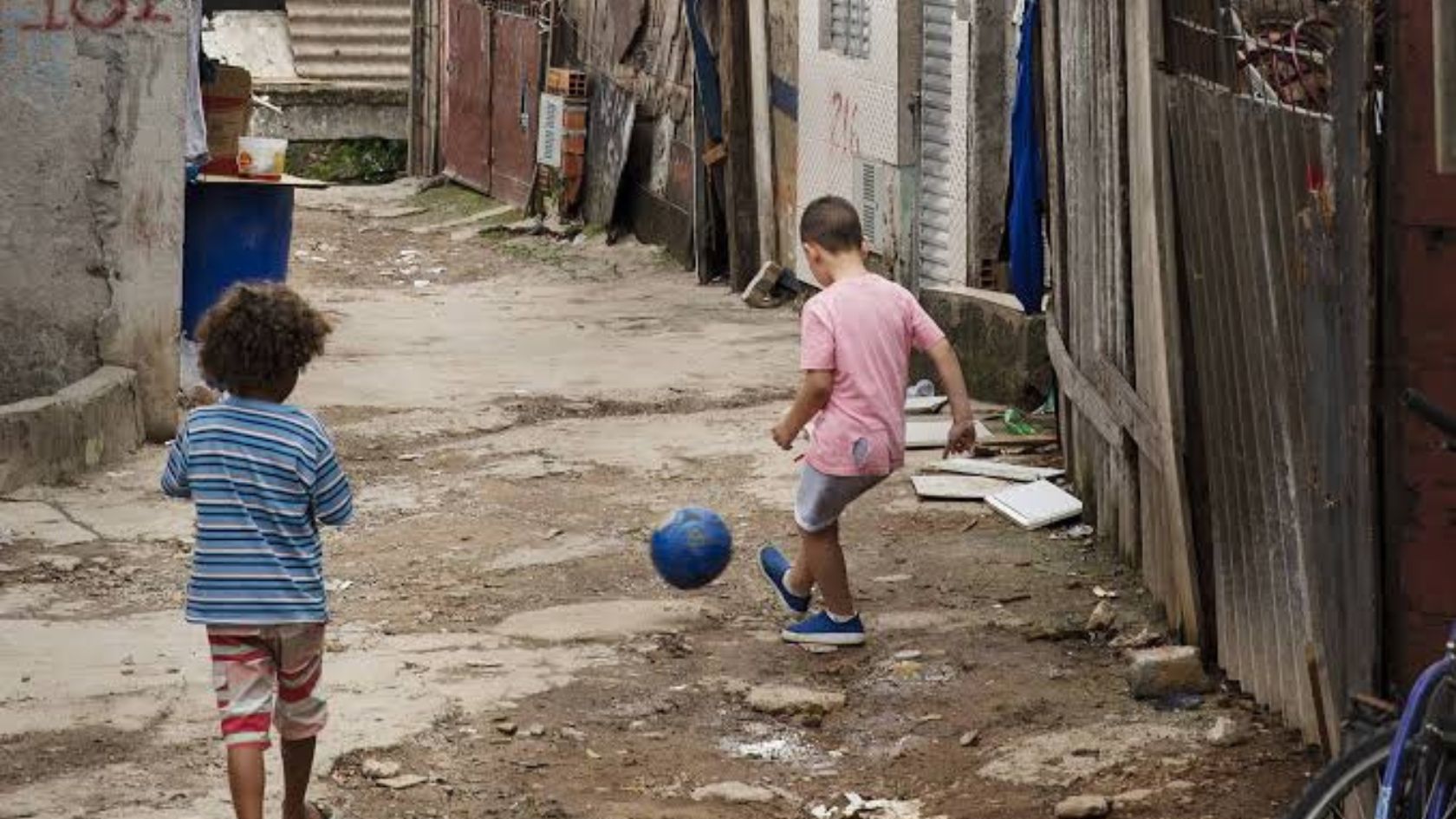 Crianças brincam com bola em rua de terra na Serra, tema da matéria sobre família acolhedora