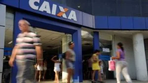 Fachada de agência da Caixa com pessoas passando, ilustra decisão do STJ sobre banco poder encerrar conta