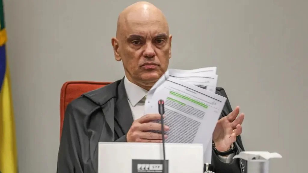 Alexandre de Moraes segura documentos durante sessão do STF, alvo de pedido de afastamento pela OAB-ES