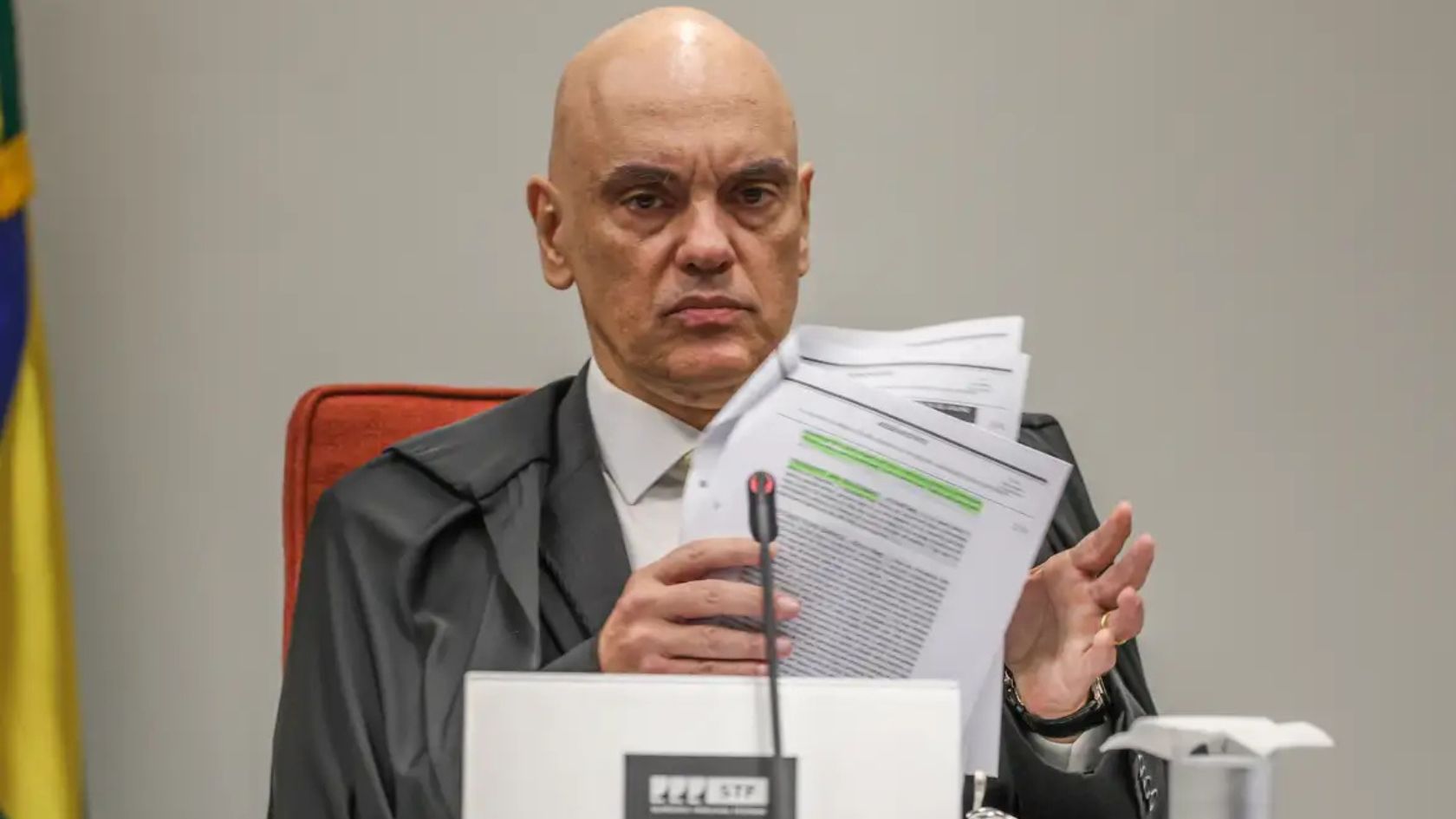 Alexandre de Moraes segura documentos durante sessão do STF, alvo de pedido de afastamento pela OAB-ES