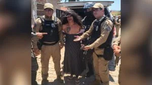 Serial killer preso na Paraíba é escoltado por policiais militares, disfarçado com peruca e vestido listrado