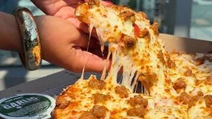 Fatia de pizza da Papa Johns puxada com queijo derretido, marca que quer entrar no Brasil