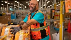 Funcionário sorri em centro de distribuição durante vagas temporárias Amazon Black Friday
