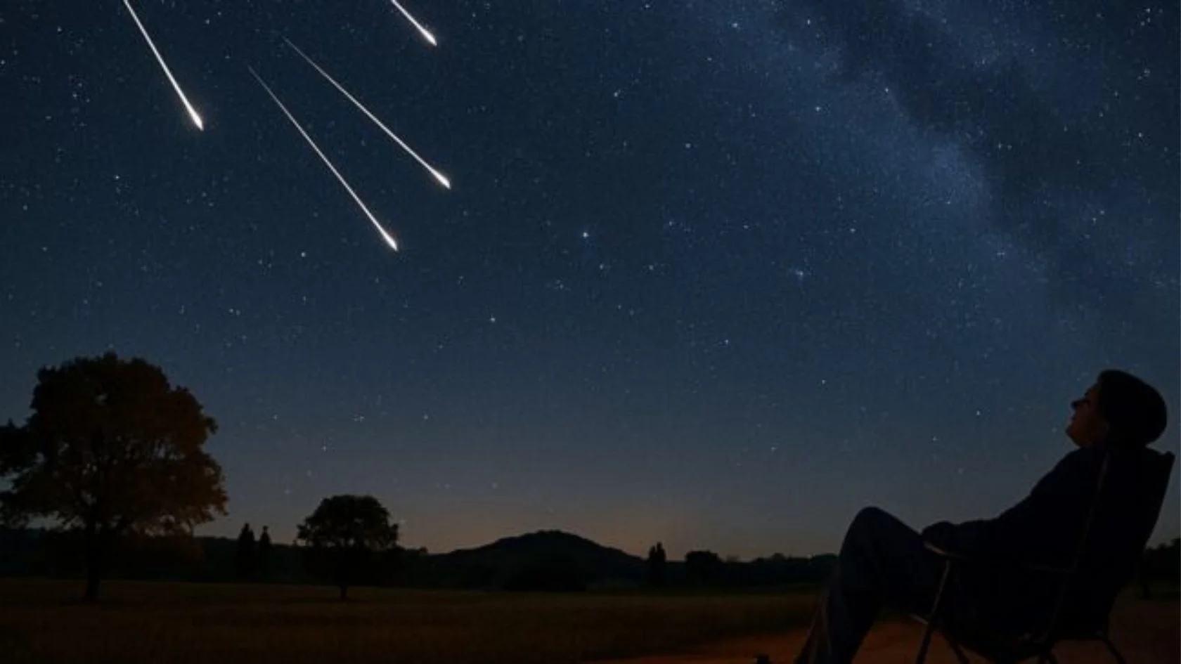 Pessoa em cadeira reclinável observa meteoros riscando o céu estrelado, ilustrando a chuva de meteoros em outubro
