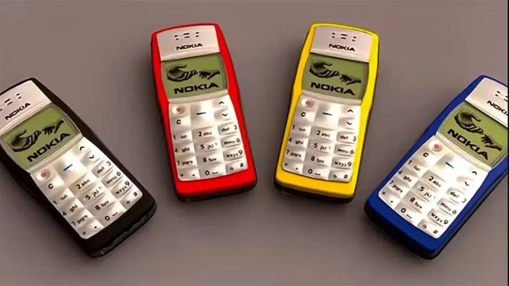 Quatro unidades do Nokia 1100 nas cores preta, vermelha, amarela e azul, lado a lado