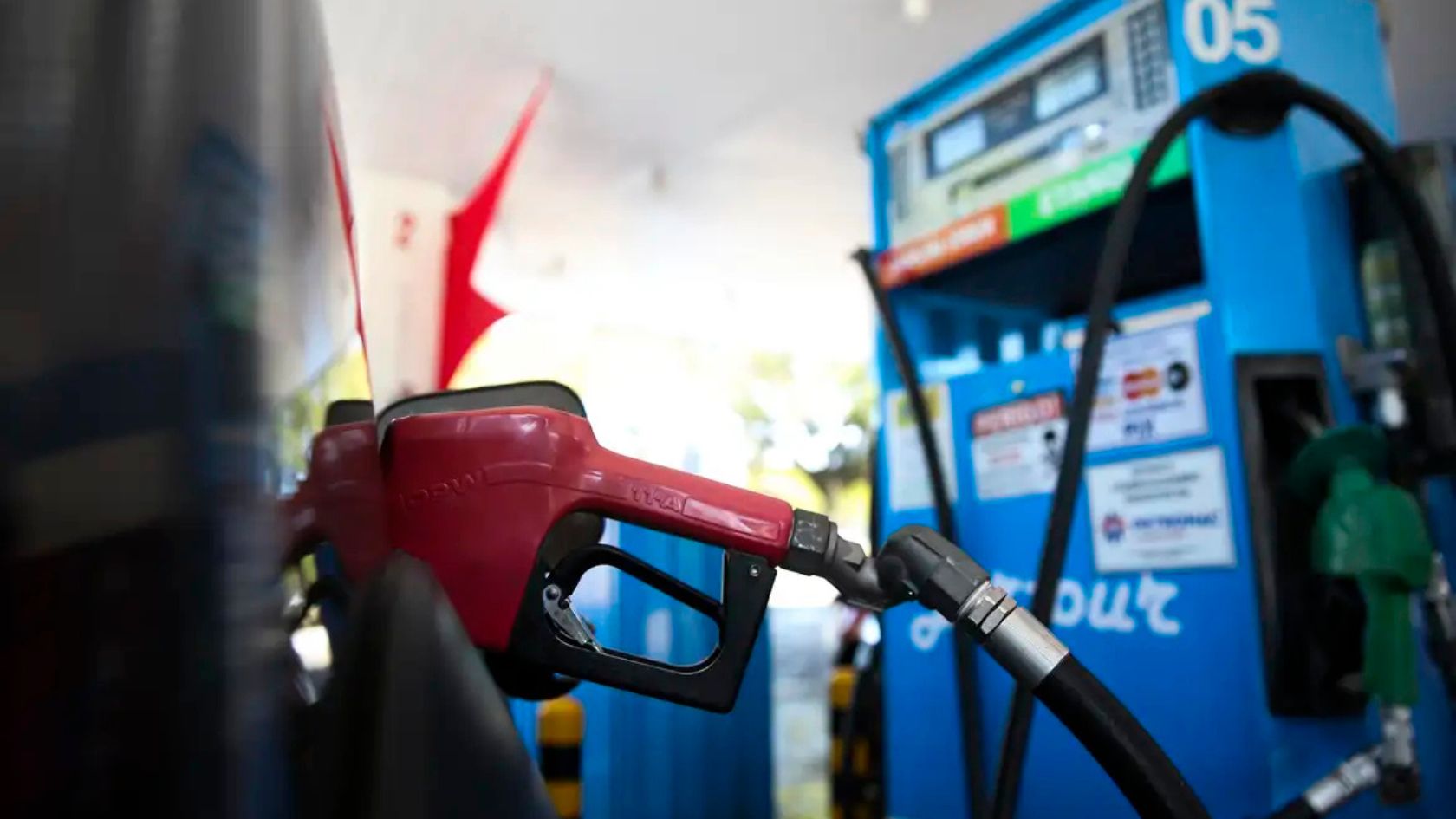 Bico de bomba abastece carro em posto, ilustrando composição do preço da gasolina no Brasil