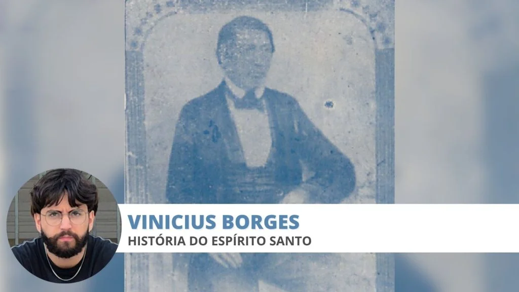 Vinicius Borges, colunista de história do Espírito Santo, ao lado de retrato antigo do padre da Serra que defendeu a Independência do Brasil