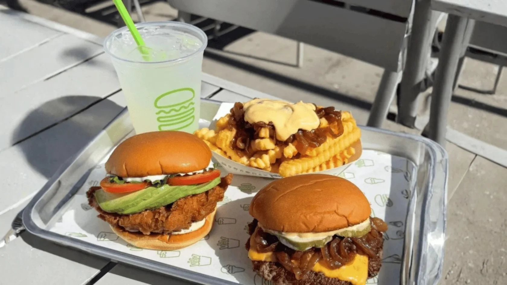 Lanches da Shake Shack em bandeja: hambúrguer, sanduíche de frango, batata e bebida; rede chega ao Brasil em 2027