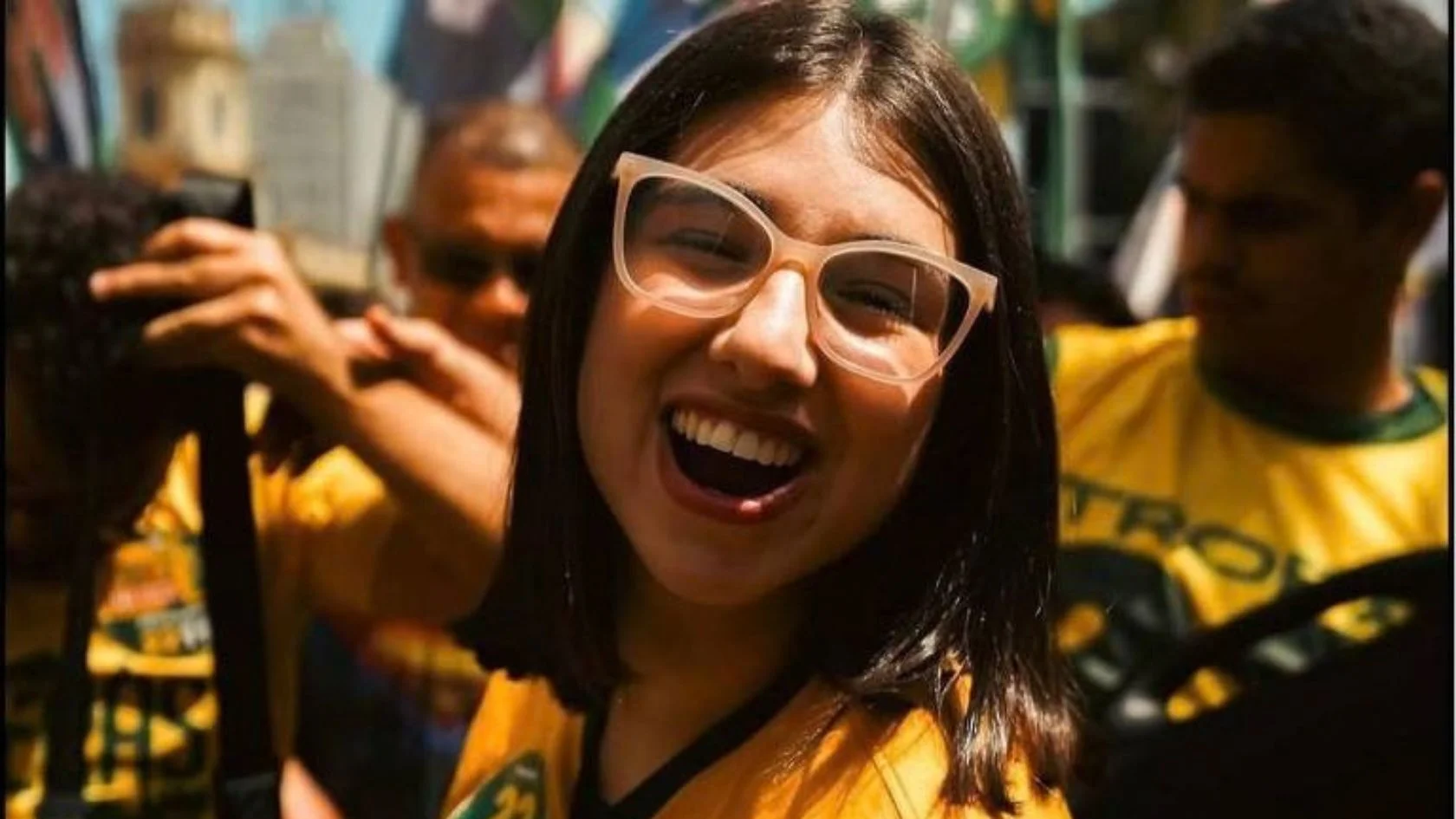 Eduarda Campopiano, deputada que copiou a lei da maconha da Serra, sorri entre apoiadores de camisa amarela