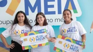 Jovens com camisetas e cartões gigantes do programa; Pé-de-Meia de outubro é pago até o dia 26