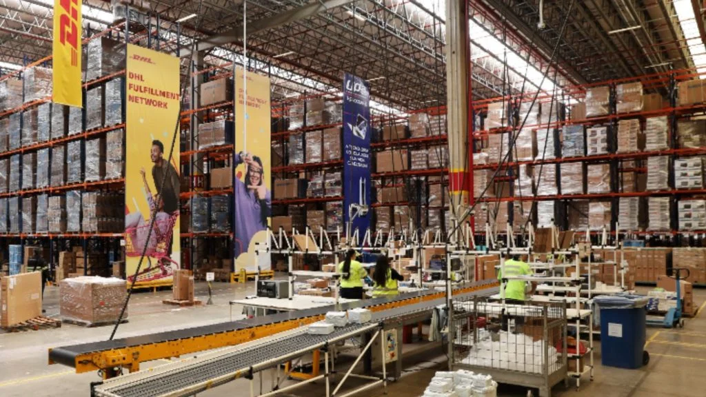Trabalhadores separam pedidos em esteira de centro de distribuição da DHL, rede que inclui a unidade da DHL na Serra