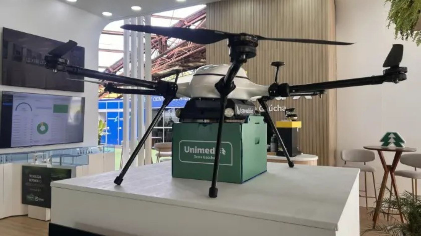 Drone para transporte de exames da Unimed Serra Gaúcha, com caixa verde acoplada, exposto em estande na Mercopar